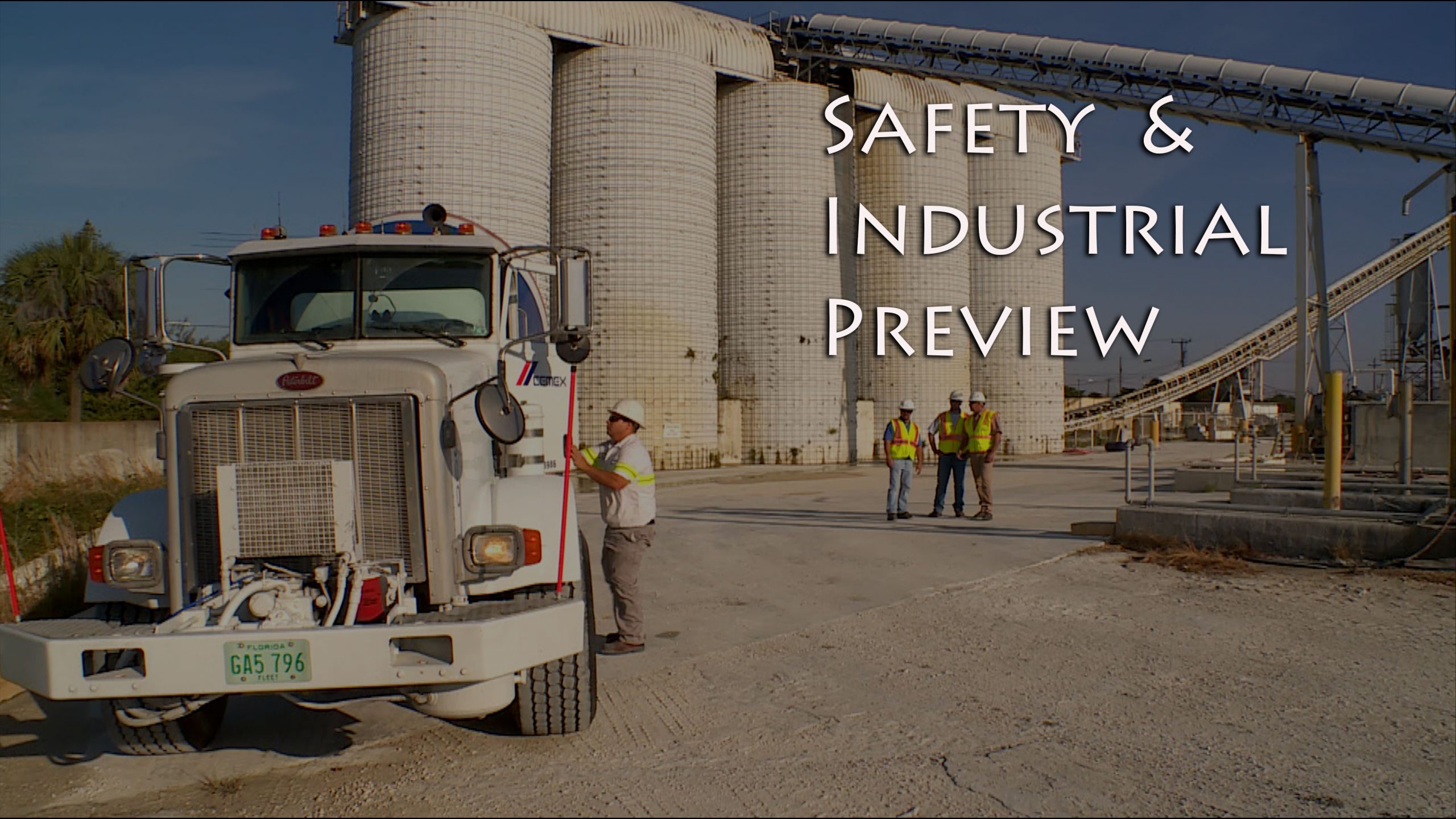 Construction crew next to silos and a truck